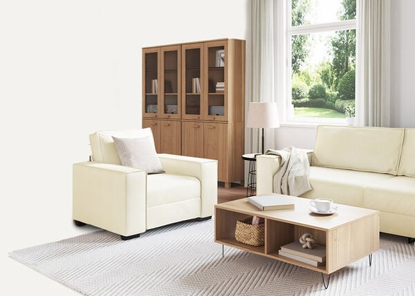 Vit 2-sitssoffa med kuddar och en pl&auml;d, inomhus.