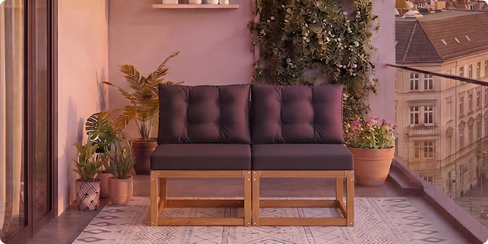  Tvåsitsig modulär träsoffa med mörkgrå kuddar på en balkong omgiven av krukväxter och stadsutsikt i bakgrunden